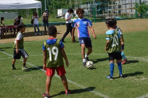 子どもたちとボールを楽しそうに蹴り合う寿一監督