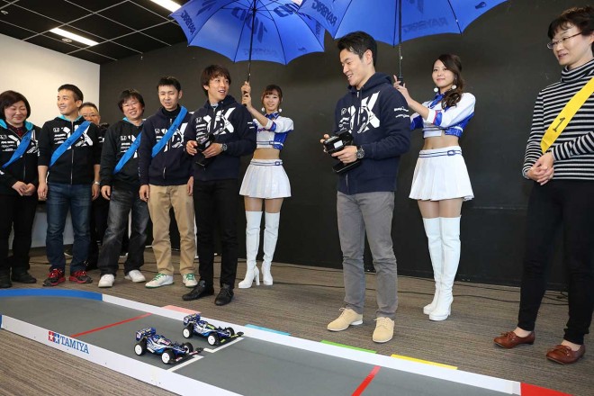 ラジコン大会ではレースクイーンが傘をさして、実際のレースウイークのような雰囲気に