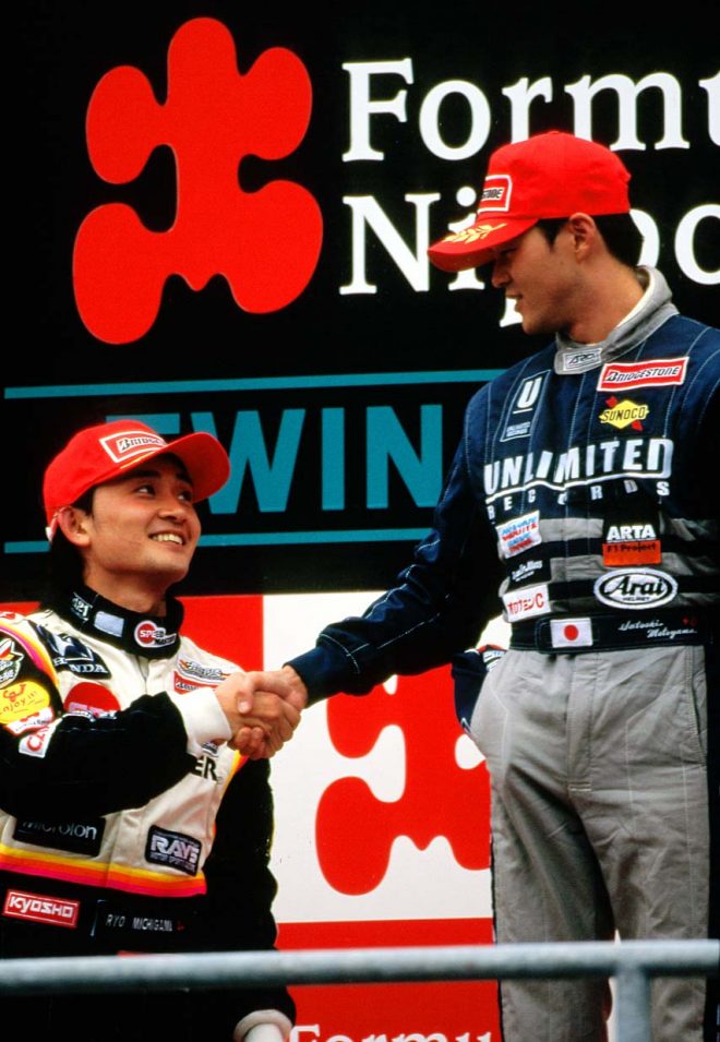 表彰台で握手をかわす本山哲と道上龍