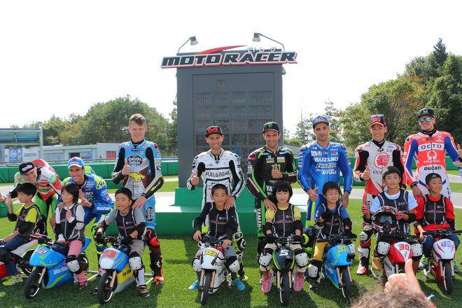 子供たちと記念撮影をするMotoGPライダーたち