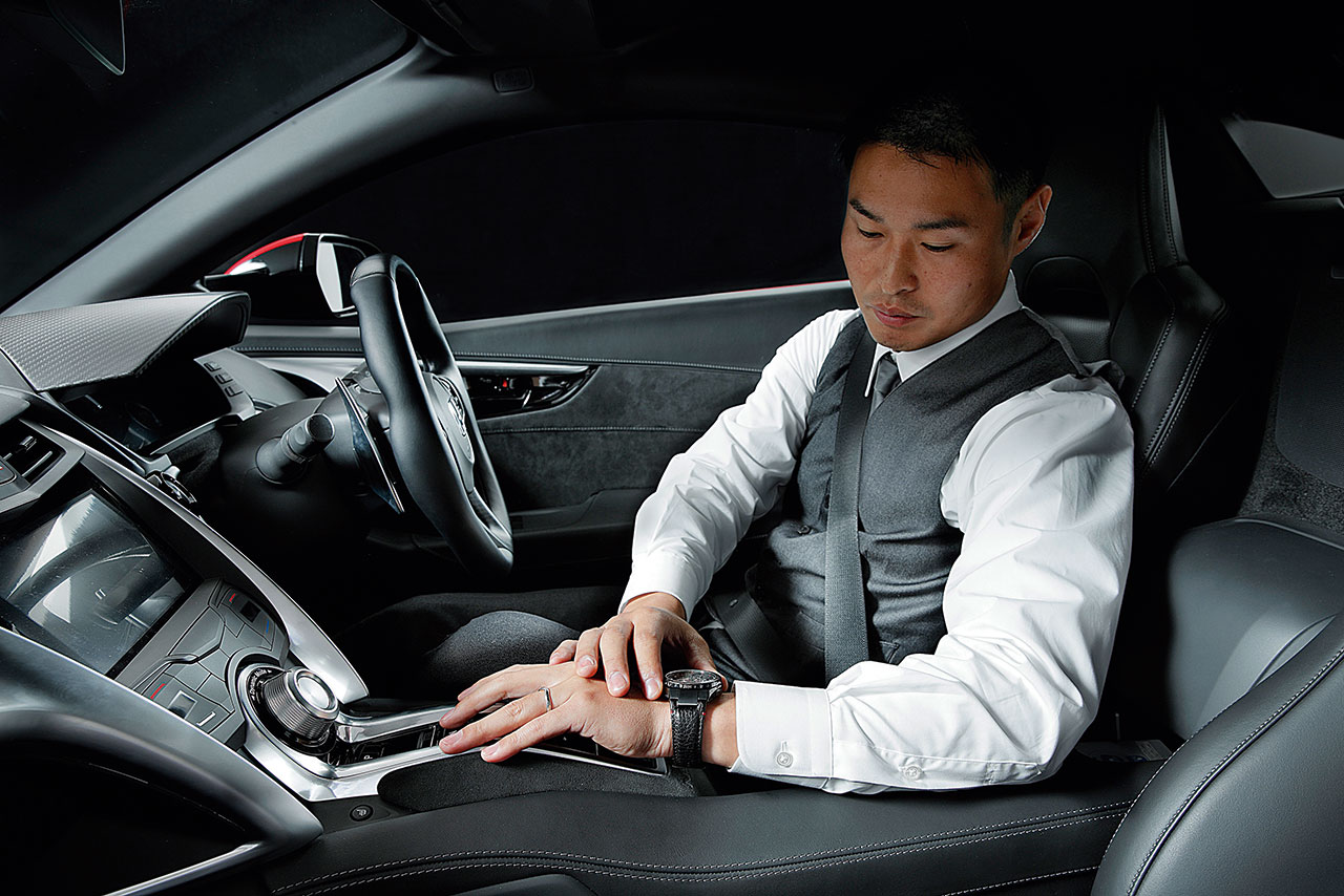 塚越はスーツ姿でホンダNSXに乗り込み、サーキットを転戦している