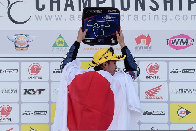 表彰台で日の丸を掲げる伊藤勇樹