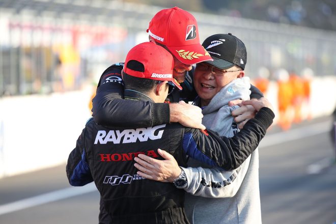 チャンピオンを獲得し、チェッカー後に抱き合った山本尚貴とジェンソン・バトン、高橋国光総監督