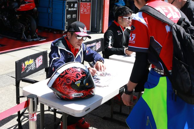 決勝日のピットウォークでファンにサインする加賀山就臣（ヨシムラスズキMOTUL）