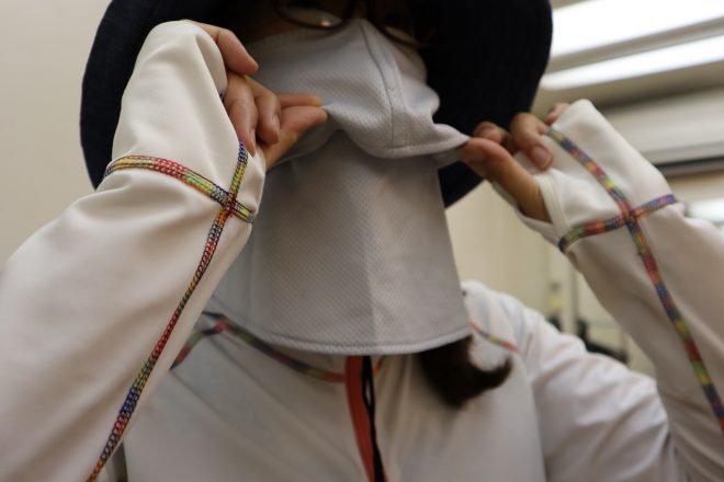 UVカットマスク、紫外線100％カットの帽子、指先ギリギリまでのラッシュガードで肌という肌を隠す女性の二人連れ。「UVカットマスクは3年前から使っています。化粧崩もなしで、完璧に日焼けしません」
