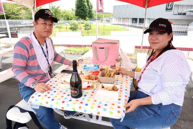 自前のテーブルクロスをひくなど、こだわりを感じられるお二人。「夏の暑さも鈴鹿の熱さも、シャンパンとともに楽しみます。鈴鹿8耐に乾杯!」
