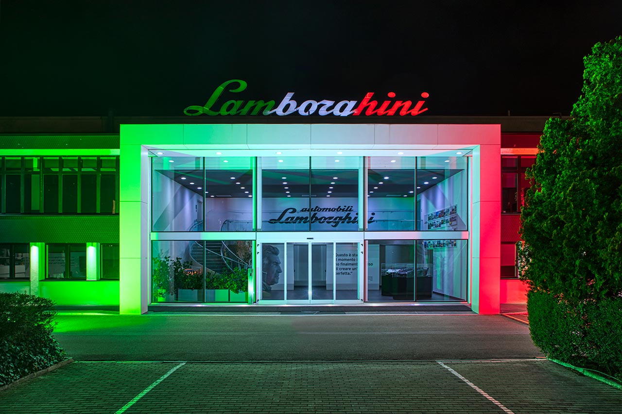 イタリアの団結と支援の象徴として、夕暮れにイタリア国旗の色にライトアップされたランボルギーニ本社