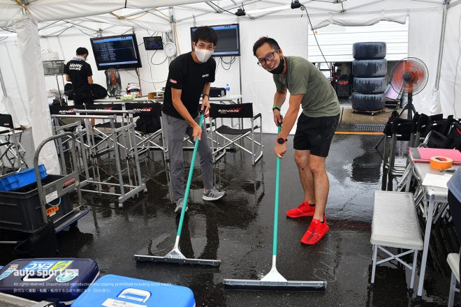 午後に降った強い雷雨のためテント内に入った水を排水する松井孝允と久保凜太郎