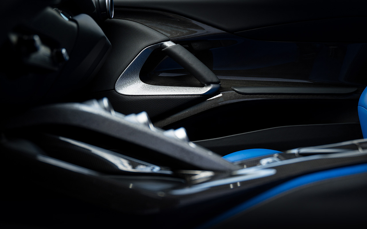 ブラックトリムをベースにエレクトリックブルーのシートが組み合わされたオモロガータのコクピット。ダッシュボードとステアリングホイールに使用された金属パーツには、ひび焼き塗装効果で仕上げられている。