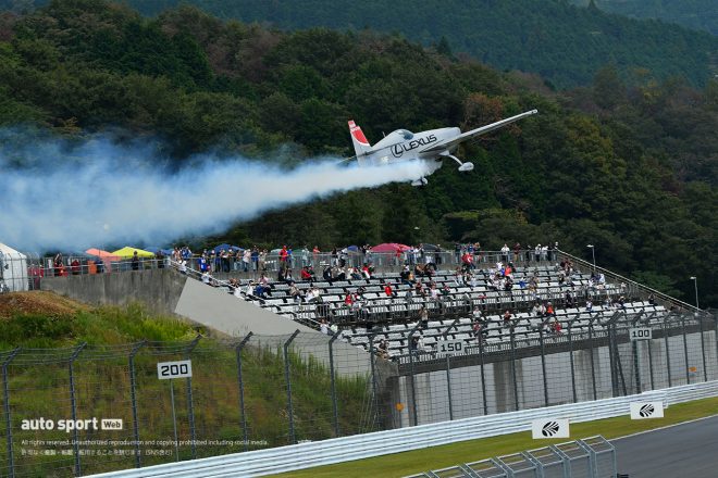 富士スピードウェイのメインストレート上をフライトする室屋義秀のエクストラ330SC