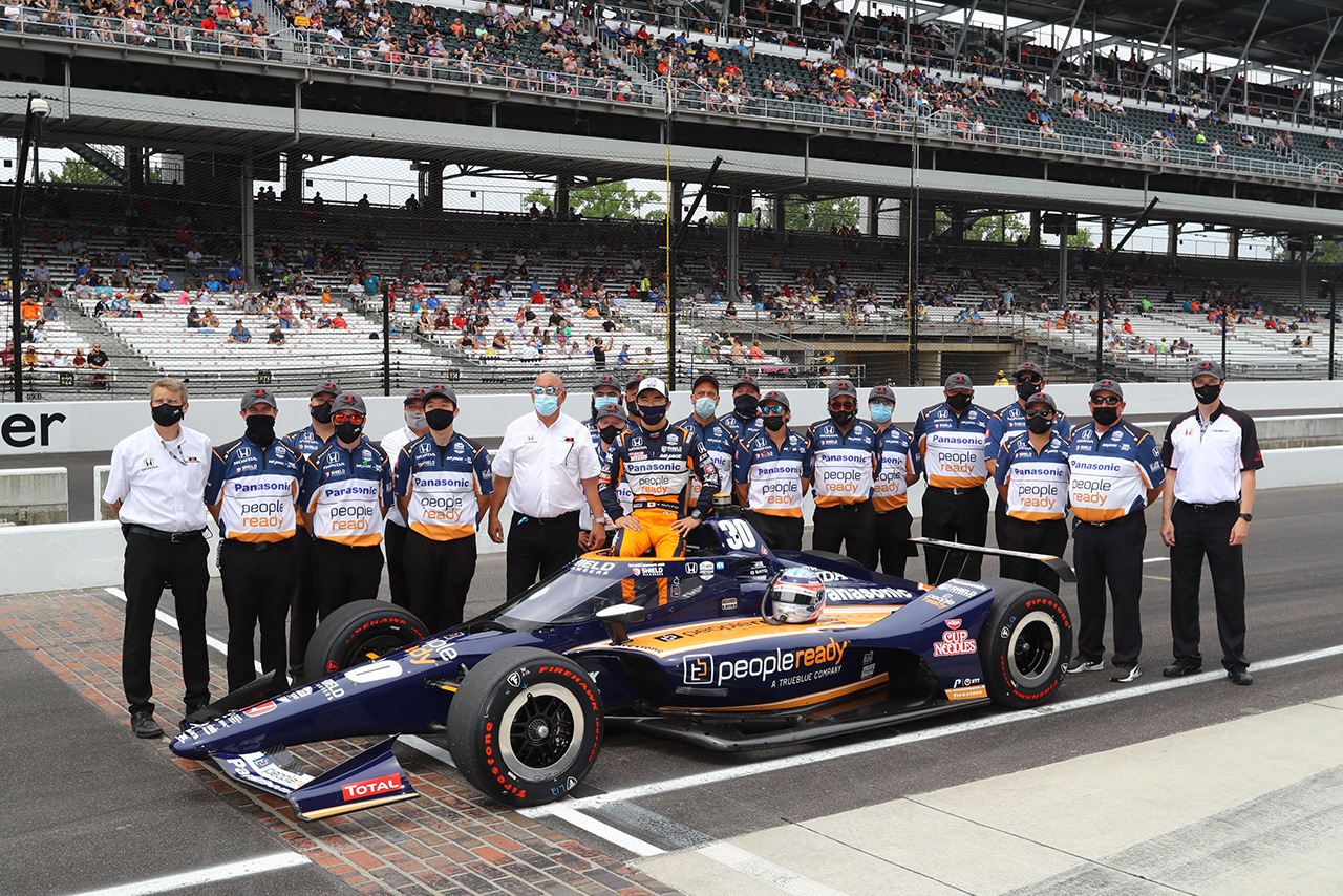 インディ500恒例のチームショットを行う佐藤琢磨と30号車のクルーたち