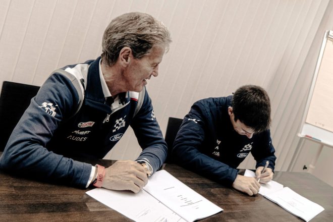 契約書にサインをするクレイグ・ブリーン(奥)とマルコム・ウィルソン(手前)