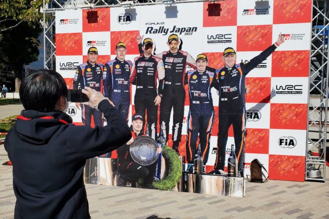 WRCの表彰台を模した顔出しパネルも設置されている。優勝ドライバー気分で写真に収まってみよう