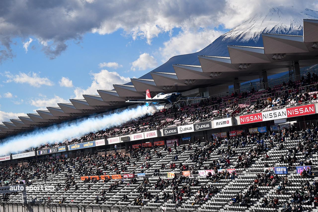 富士スピードウェイのメインストレート上をフライトする室屋義秀のエレクトラ330SC