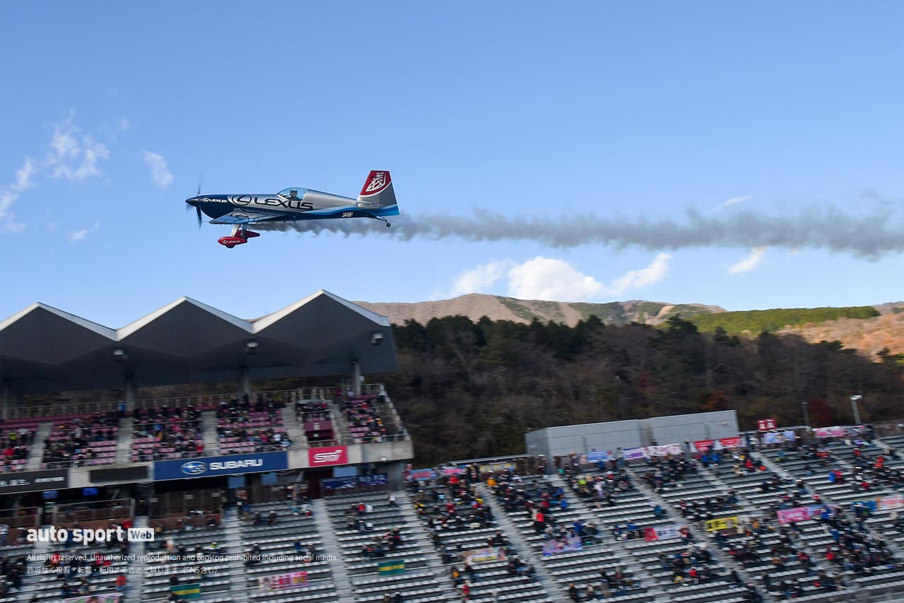 富士スピードウェイのメインストレート上をフライトする室屋義秀のエレクトラ330SC