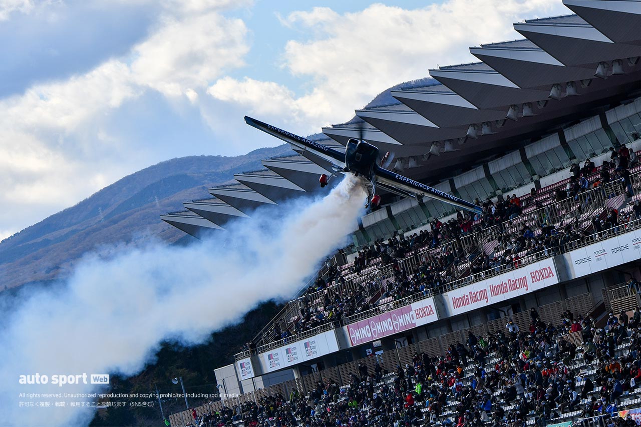 富士スピードウェイのメインストレート上をフライトする室屋義秀のエレクトラ330SC