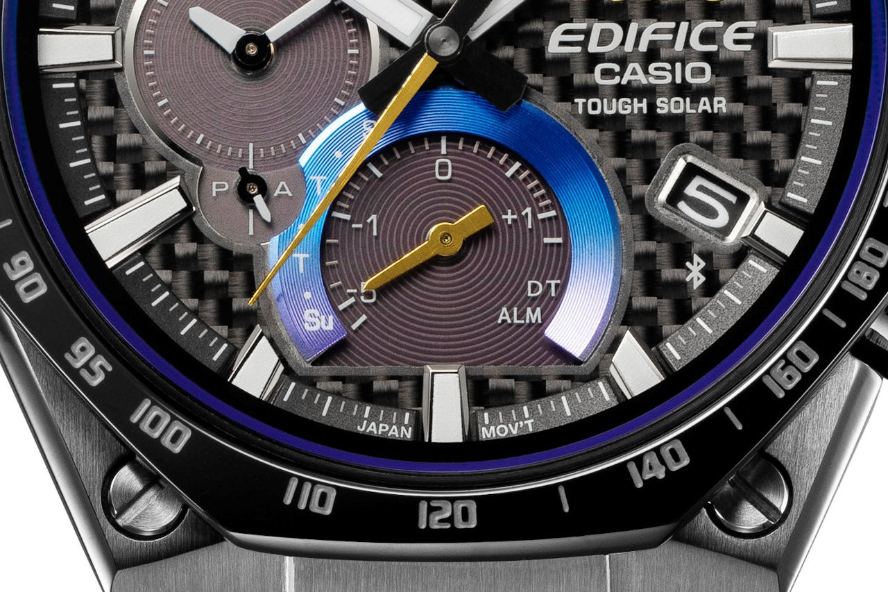 TOM'Sロゴと秒針、インダイアルの小針にゴールドカラーを施し高級感を演出。6時位置のインダイアルと風防の外周にはグラデーションカラーをあしらい、チタンマフラーで見られるヒートグラデーションが表現された