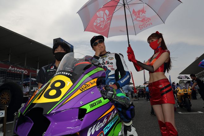 大久保光選手（EVA RT Webike TRICKSTAR Kawasaki）。レースクイーンの五十嵐希さんはアスカ仕様。もかして、パラソルはATフィールドを模している？