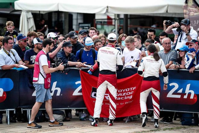 トヨタGAZOO Racingのフラッグを掲げるファンと交流するリシャール・ミル・レーシングのセバスチャン・オジエ