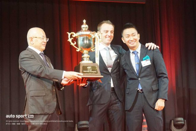 GT500ドライバーズチャンピオントロフィーを受け取り笑顔をみせるベルトラン・バゲットと平峰一貴