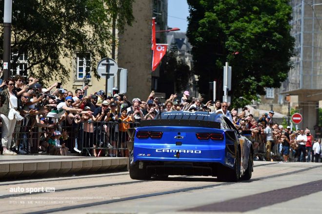 車検後のパレードで公道上のトラム軌道上を走行するヘンドリック・モータースポーツのシボレー・カマロZL1