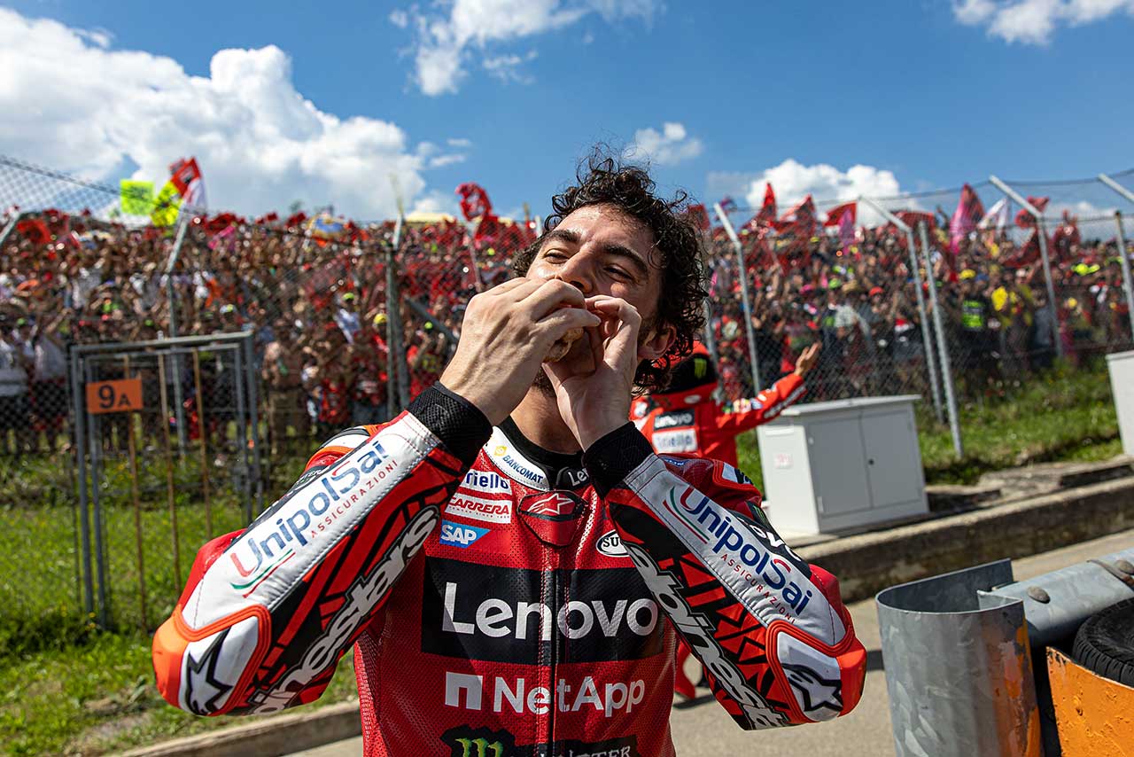 レース後のパフォーマンスでホットドッグをかじるバニャイア