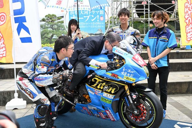 浜松チームタイタンのマシンにまたがりライディングフォームをレクチャーされる中野浜松市長