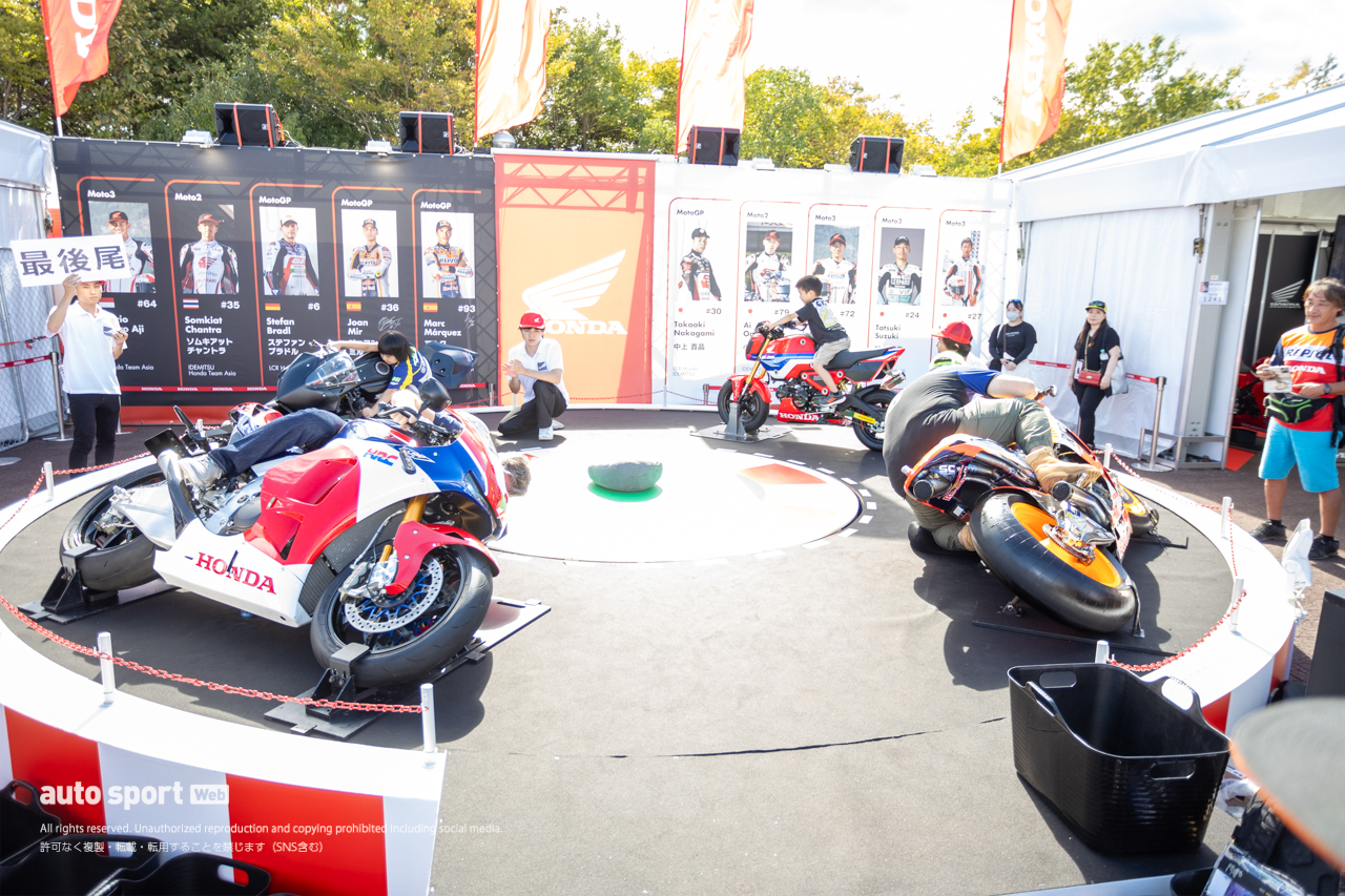 鈴鹿8耐でも盛況だったホンダブースのメリーGOラウンド。ハングオン状態のマシンに跨りMotoGPライダーさながらのコーナリング？を味わえます