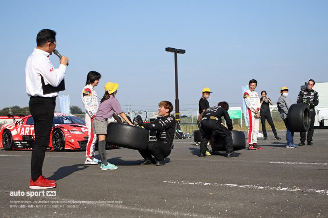 メカニックと一緒に実際にタイヤを持ち上げる子どもたち