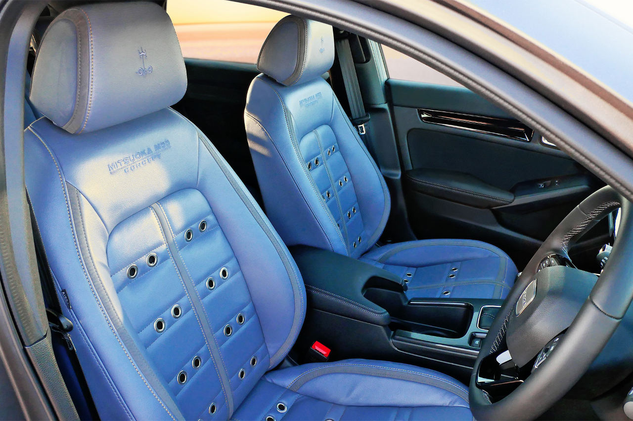 鮮やかなブルーが目を惹くインテリア。シートには1970年代のスポーツシートの通気孔を想起させる金具が施されている