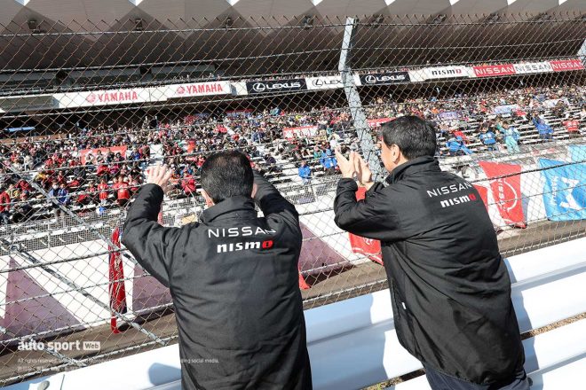 グランドスタンドのファンたちに手を振る片桐CEOと内田社長