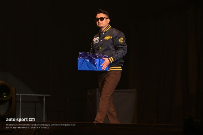 謎の発泡スチロール箱を持って日本レースクイーン大賞2023表彰式に登壇する坂東正敬監督