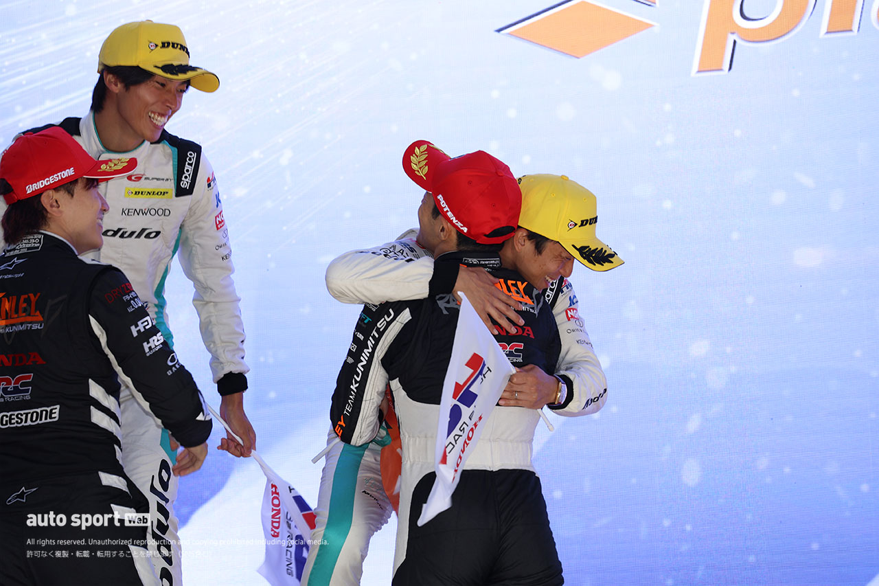 表彰式で抱き合う伊沢拓也と山本尚貴