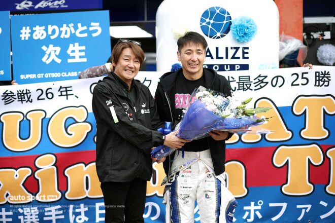 2025年スーパーGT第8戦もてぎ決勝前のピットウォークでは近藤真彦監督からの花束を受ける松田次生
