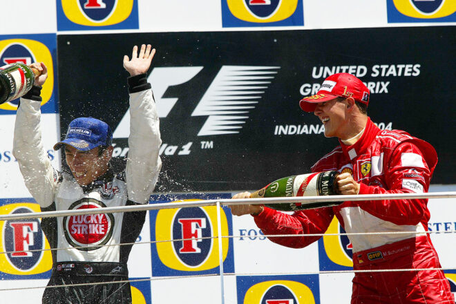 2004年F1第9戦アメリカGP　3位初表彰台の佐藤琢磨（BARホンダ）をシャンパンファイトで祝福するミハエル・シューマッハー（フェラーリ）
